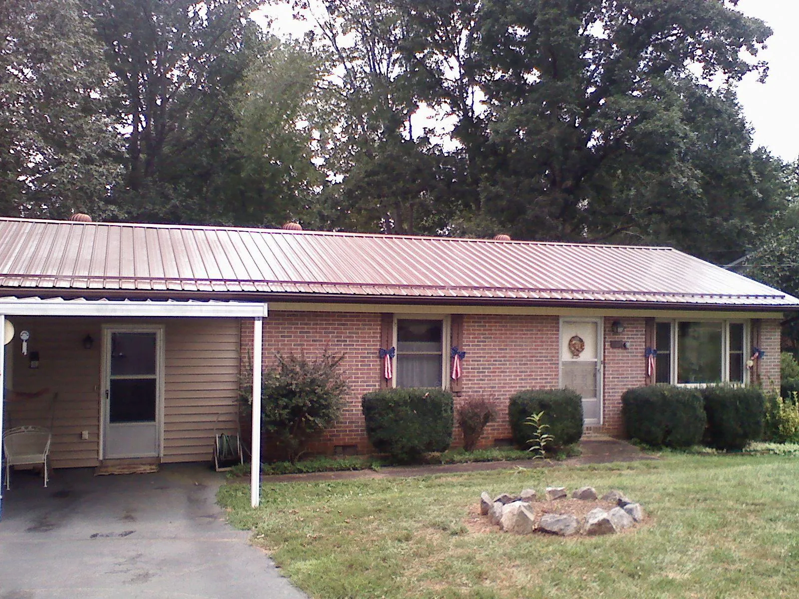 Bronze metal roof and carport on a brick ranch home — Roof Repair work by our crew in Millersburg