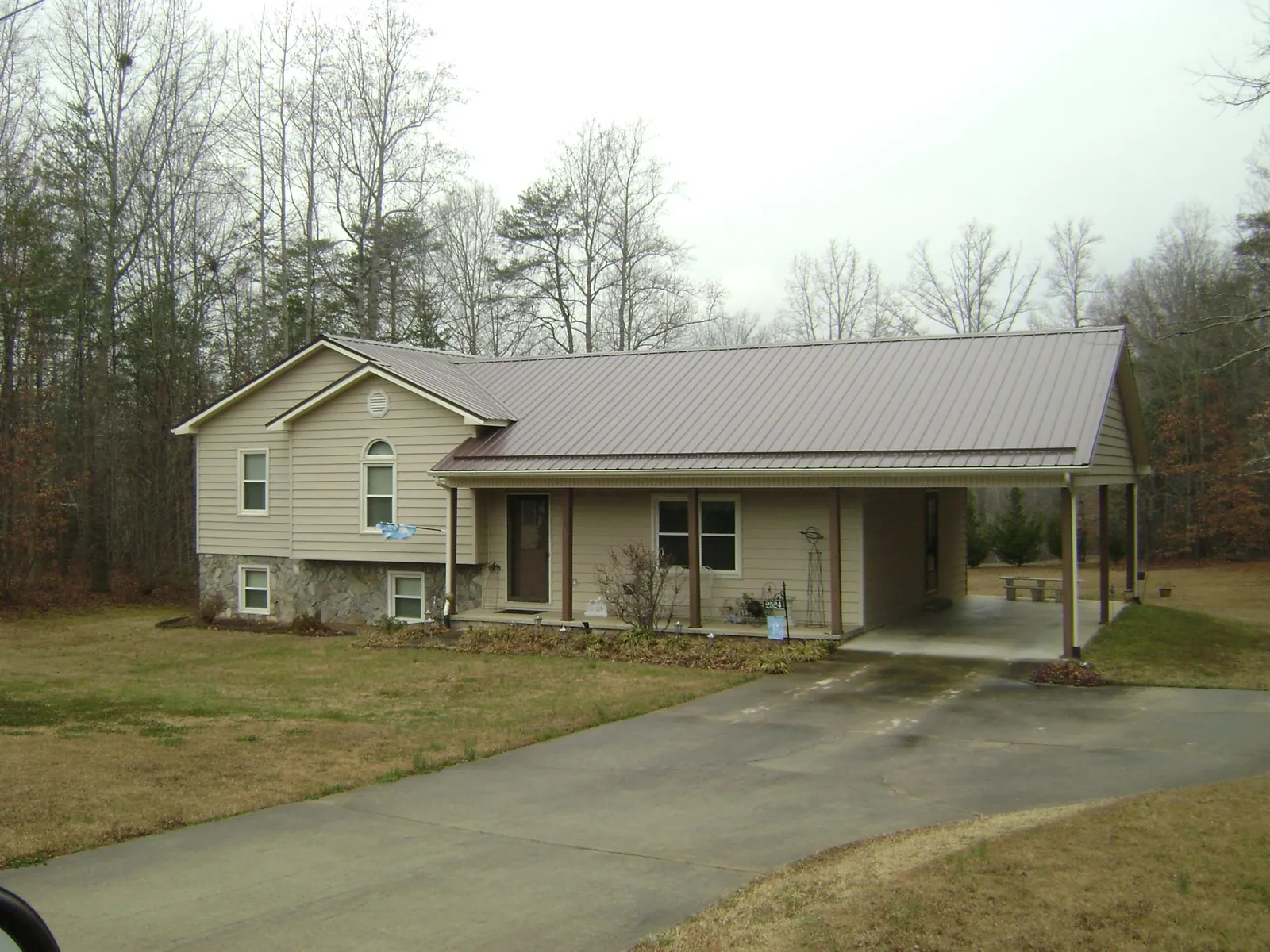 Brown metal roof on a tan split level home with an attached carport in Millersburg